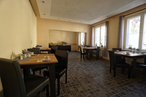 巴德马斯考Pension Am Park的用餐室设有桌椅和窗户。