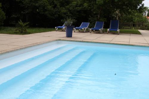 BouayeGite de la Laiterie的一个带蓝色椅子和桌子的游泳池