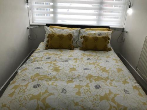 Mile EndDolly Cottage Colchester的一间卧室配有一张带鲜花棉被的床