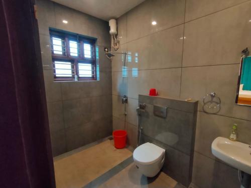 坎努尔Nandhanam Holidays的浴室配有卫生间、淋浴和盥洗盆。
