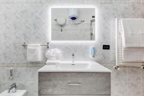 钱皮诺Joker House Roma in 15 minuti Station Airport的白色的浴室设有水槽和镜子