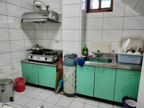Juguang东莒幸福屋民宿的一间带水槽和炉灶的小厨房