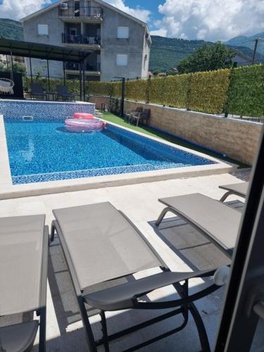 蒂瓦特Villa with Pool & Garden apartment 1 Ognjen的一个带两把椅子和飞盘的游泳池