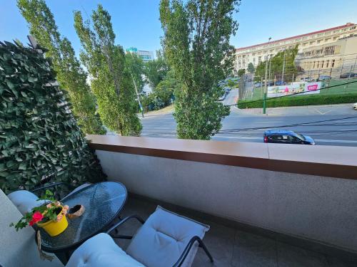 马马亚Iaki Apartment Mamaia的阳台配有桌椅,享有街道的景色。