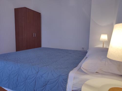 波弗加纳Povljana Maris的一间卧室配有一张带蓝毯的床和橱柜