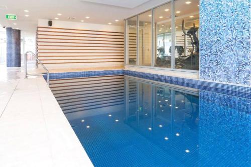 格莱内尔格Colley 11-11 Sub-Penthouse Luxurious Glenelg的游泳池拥有蓝色瓷砖墙和蓝色瓷砖
