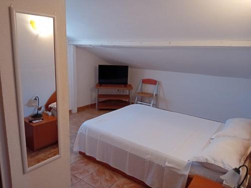 南埃福列casa andrei m的卧室配有白色的床和电视。