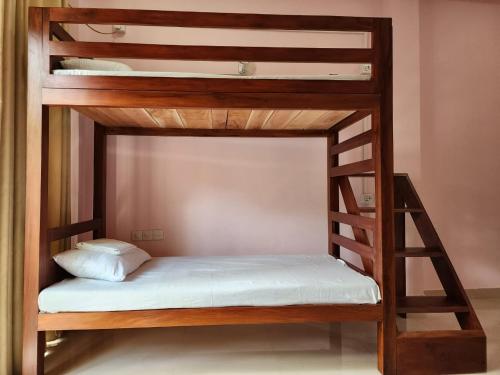 尼甘布Cross Ceylon的一张带白色床垫的木制双层床