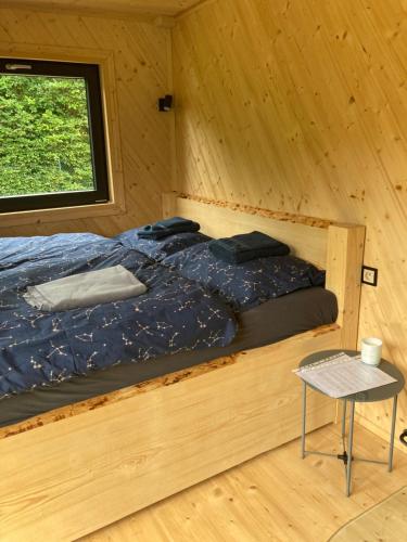 ZátorObytný kontejner Cabin Stars的木制客房的一张床位,设有窗户