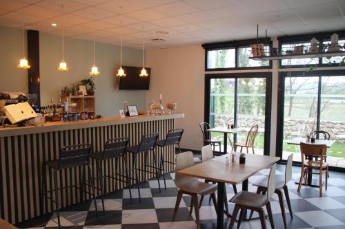 SoyonsLa Gare Soyons的餐厅设有桌椅和窗户。