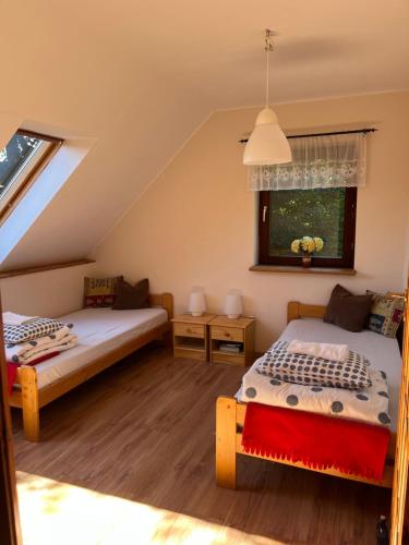 RzeczkaDom w Rzeczce Góry Sowie的阁楼卧室设有两张床和窗户。