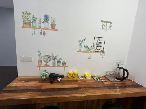 乔治市sungai ujong home stay的墙上挂着一束植物的木桌