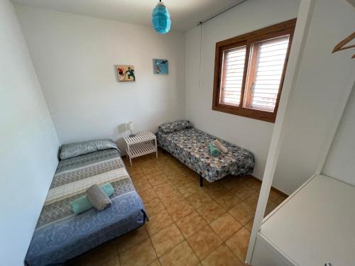 阿尔塔夫拉El Xalet d’en Joan Maria d’Altafulla的小房间设有两张床和窗户