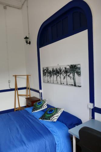 摩亚Atlantis Surf Hostel的一间卧室,配有蓝色的床和棕榈树