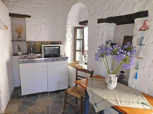 阿诺锡罗斯Philoxeno Traditional house - Ano Syros的厨房配有桌子和紫色花瓶