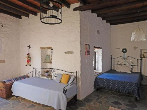 阿诺锡罗斯Philoxeno Traditional house - Ano Syros的一间卧室配有两张床和吊灯。