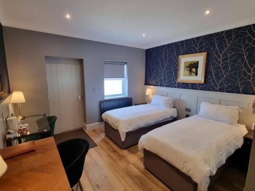 Stoke Albany白马旅馆及餐厅的酒店客房设有两张床和一张桌子。