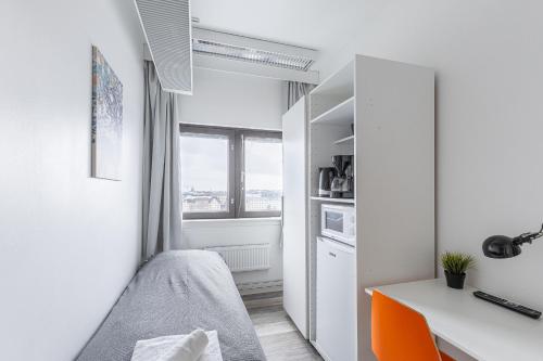 赫尔辛基Sky Hostel Helsinki的一间小卧室,配有一张床和一张书桌
