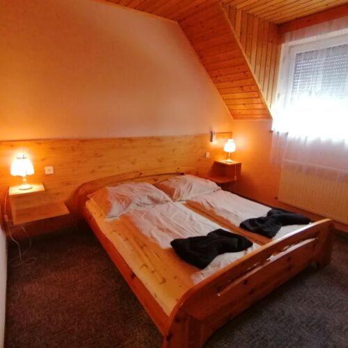 巴拉顿博格拉尔Malom Fogadó的一间卧室配有木床和2条毛巾