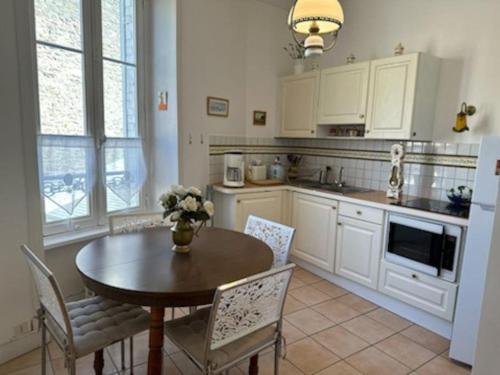 迪纳尔Charmant T2 saint Enogat的厨房配有桌子和桌椅