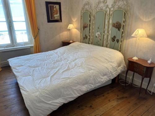 迪纳尔Charmant T2 saint Enogat的卧室配有一张带两张桌子的大型白色床