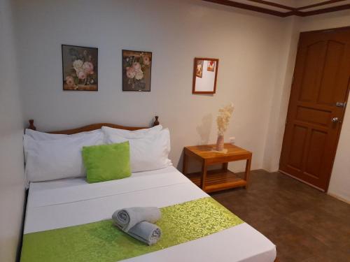 爱妮岛MilVir Tourist INN的卧室配有白色床和绿色枕头