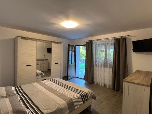 克尔茨什瓦拉乡CASA ANDREI的一间卧室设有一张床和一个滑动玻璃门