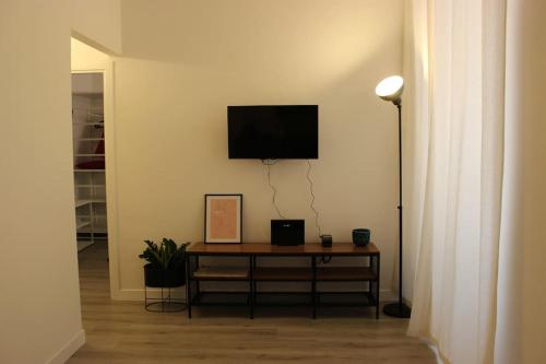 罗马Colosseo Living Suites的客厅配有桌子,墙上配有电视