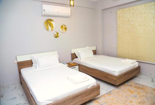 马斯喀特AECO lovely 2 bedroom apartment for family and friends的白色墙壁客房的两张床