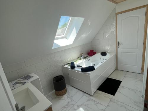 CordéacLe cocoon Isérois, avec balnéo的白色的浴室设有水槽和窗户。