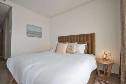 阿加迪尔New Sea Front Apartment 135mq with Unlimited Wi-Fi的卧室配有一张带白色床单和枕头的大床。