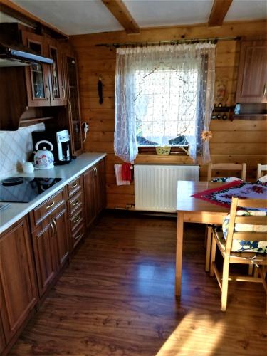克雷尼察Adelka-dom przy stoku的厨房配有木制橱柜、桌子和窗户。