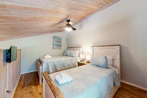 埃迪斯托艾兰Driftwood Villa - 261 Palmetto Perch的配有木天花板的客房设有两张床。