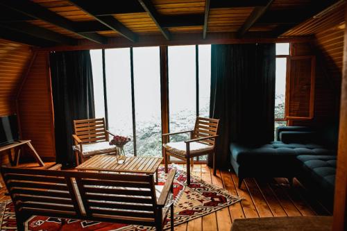 特拉布宗اكواخ خشبية للايجار اليومي的客厅配有两把椅子和一张桌子,位于窗户前