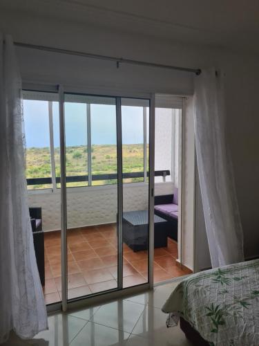 艾西拉Asilah Marina Golf的卧室设有滑动玻璃门,可通往阳台
