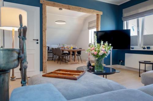 韦斯特兰Backbord的客厅拥有蓝色的墙壁和鲜花桌