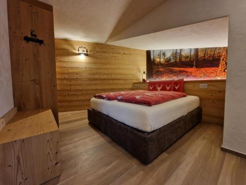奥加Oga Sweet Home的卧室配有一张床铺,位于带木墙的房间内