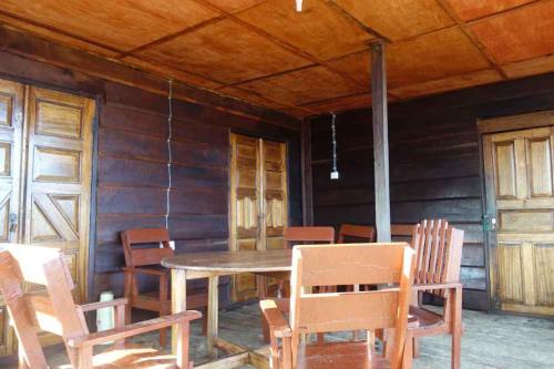 Bure TownRobinson's Hut的一间带木桌和椅子的用餐室