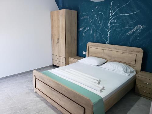 卡萨米尔Villa Luan Ksamil的一间卧室配有一张大床和木制床头板