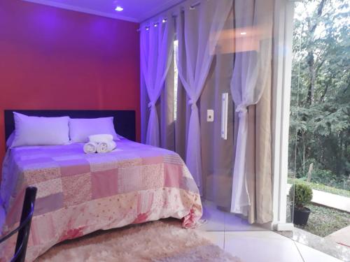坎波斯杜若尔当Parada Di Maria Guest House的紫色卧室设有一张床和一个窗户