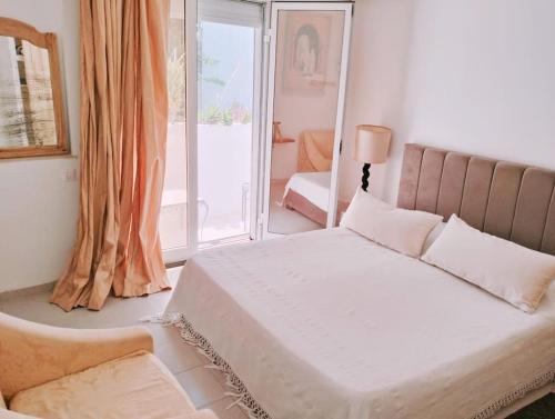 El HaouachSpacieuse et Cosy的一间卧室配有一张床、一张沙发和一个窗口