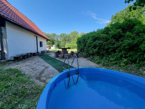 VetepereRummusaare puhke- ja spordikeskus的一座带野餐桌的房屋前的游泳池