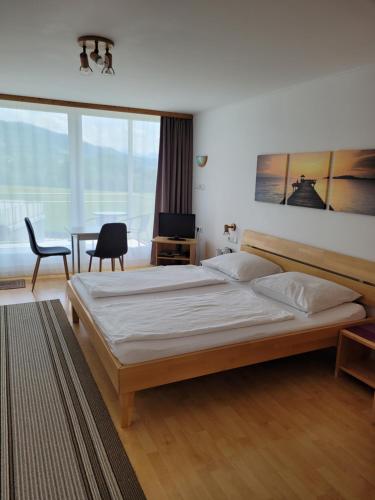 赫尔布兰茨Gästezimmer Suppan的一间卧室配有一张大床和一张桌子及椅子