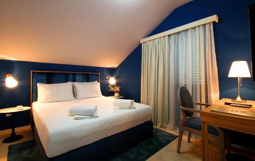 科托尔Panonija的酒店客房配有一张床、一张书桌和一张书桌。