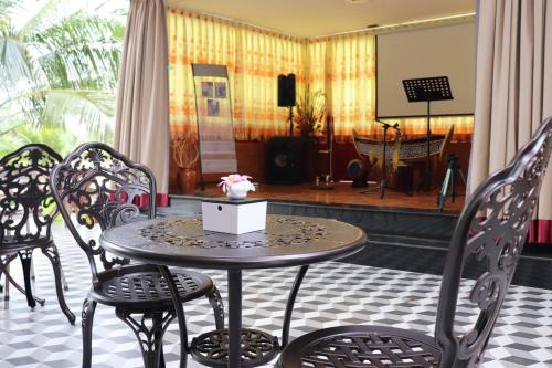 磅湛Toek Chha Temple Resort的桌子和椅子,位于带舞台的房间