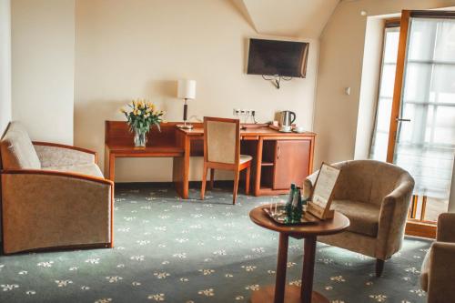 切拉季莱塞斯基酒店的客厅配有桌子、椅子和桌子