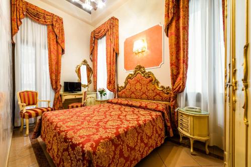 威尼斯埃尔凡高酒店的一间卧室配有一张红色床罩的床