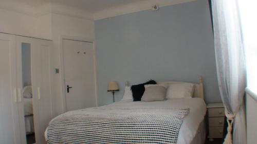 伯恩茅斯Vernon Lodge Flat 2的白色卧室配有带白色枕头的床