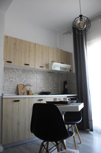 Néa KhilíStuDio 57(10)的厨房配有木制橱柜、水槽和2把椅子