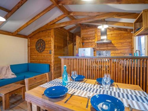 派拉索梅Camping de la Dune "Les Flots Bleus"的一间带桌子和蓝色沙发的用餐室
